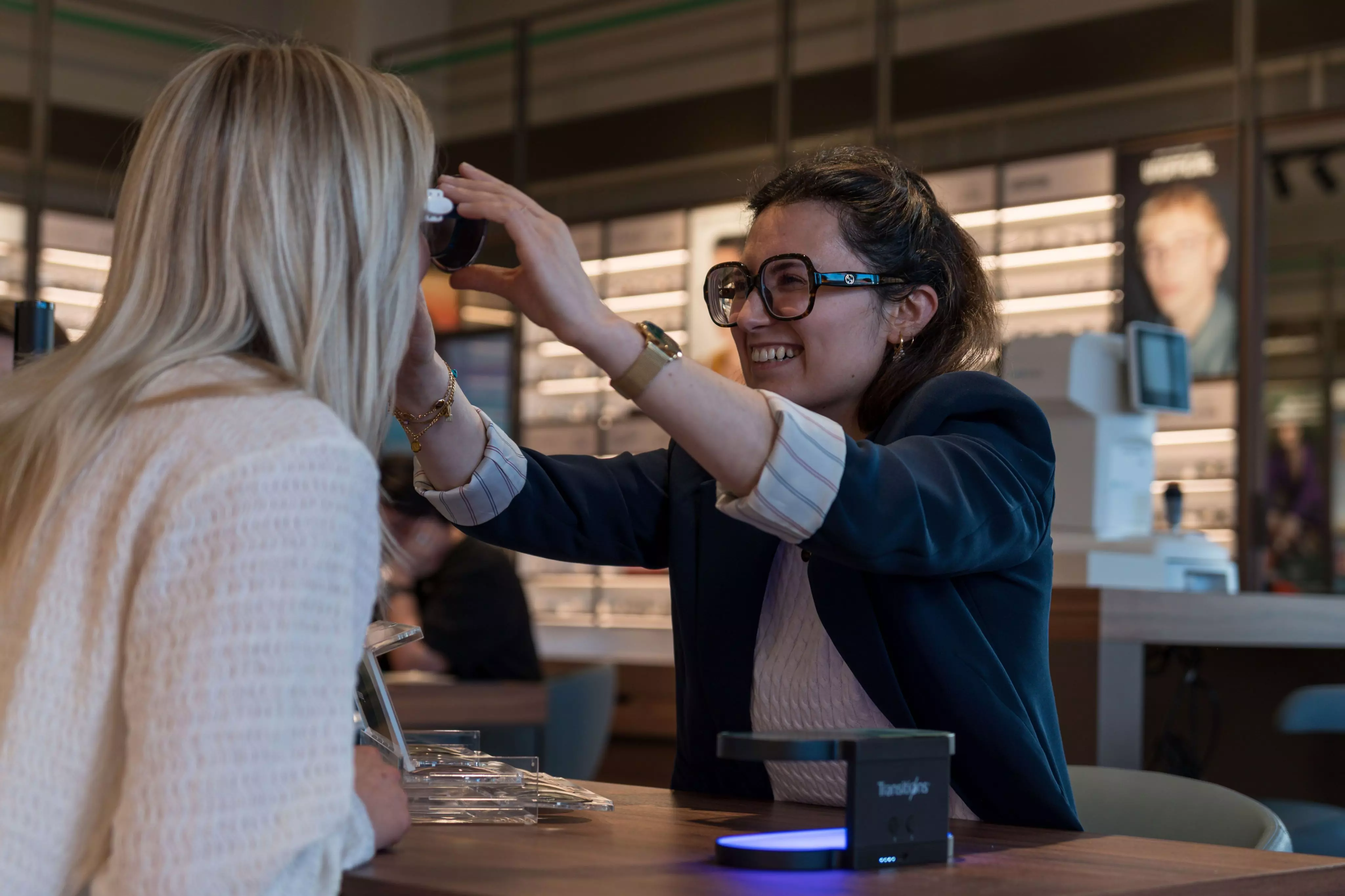 Zelfstandig zaakvoeren bij Pearle  Zelfstandig zaakvoerder Nareen lachend op de foto met een klant terwijl ze het effect van transitions glazen bekijken