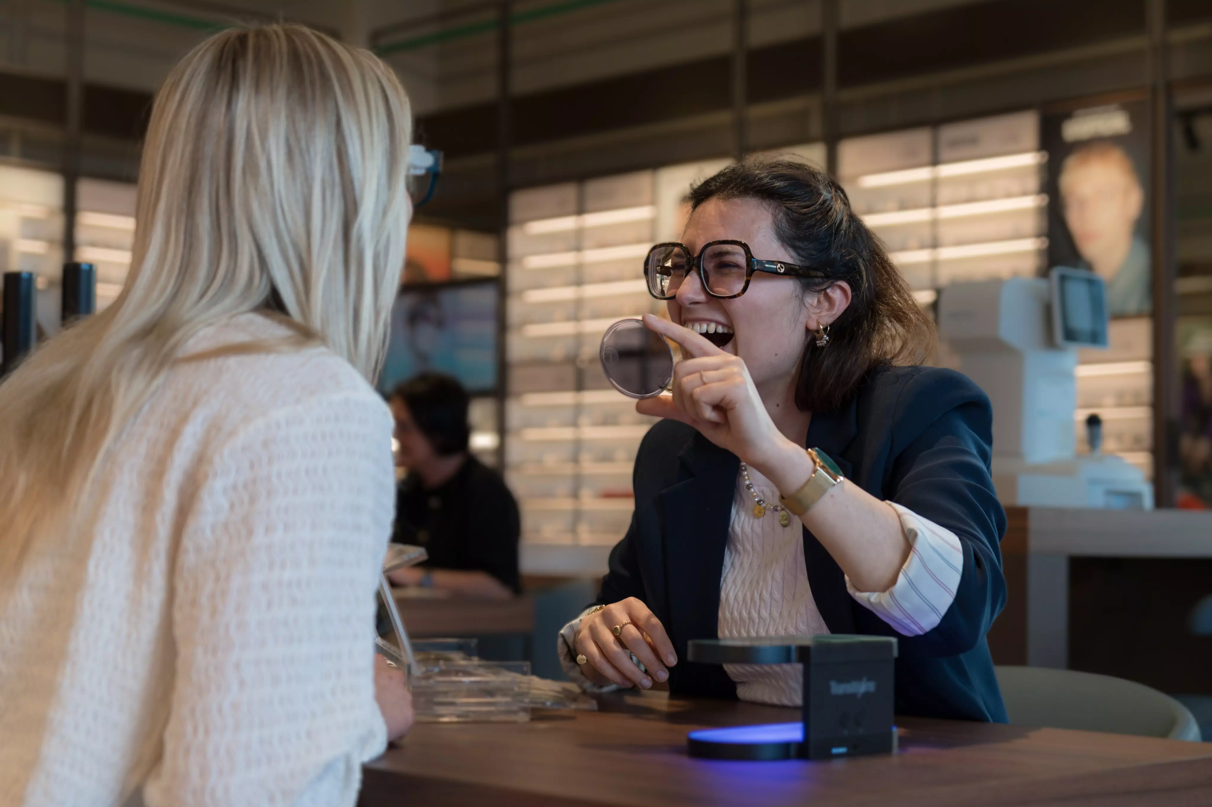 Zelfstandig zaakvoeren bij Pearle  Zelfstandig zaakvoerder Nareen lachend op de foto met een klant terwijl ze het effect van transitions glazen bekijken