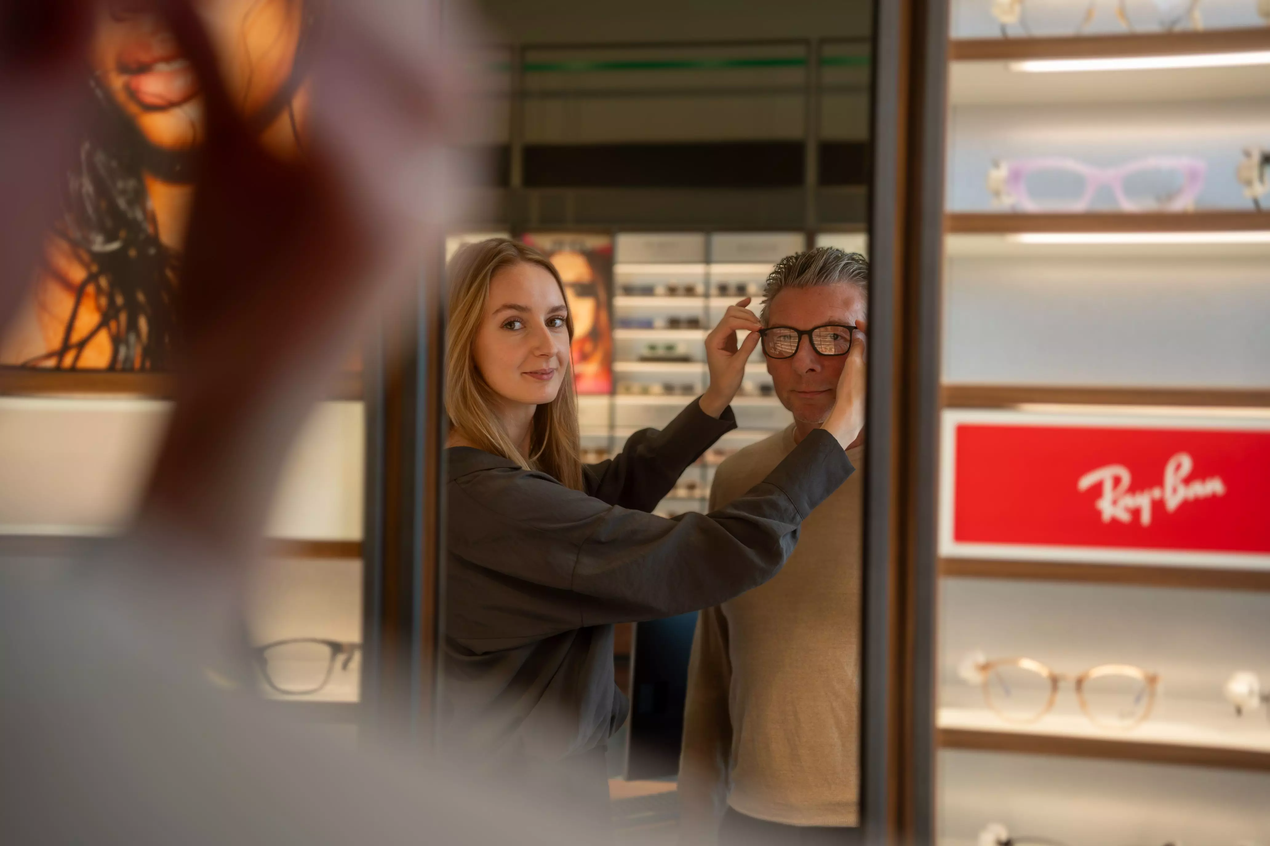 Karlien opticien in opleiding bij Pearle Pearle medewerker past montuur aan bij een klant